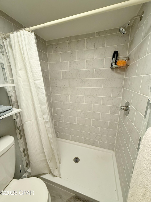 bathroom featuring a shower with curtain and toilet