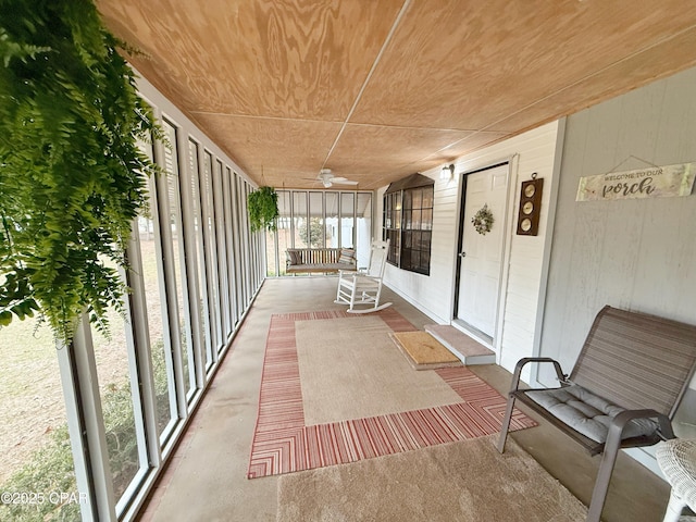 unfurnished sunroom with ceiling fan and wooden ceiling