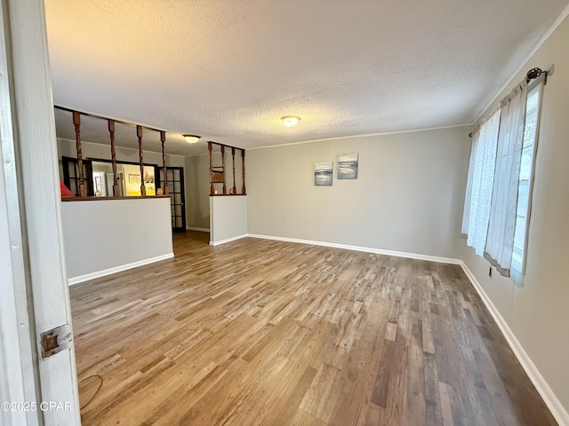 unfurnished living room with a textured ceiling and hardwood / wood-style flooring