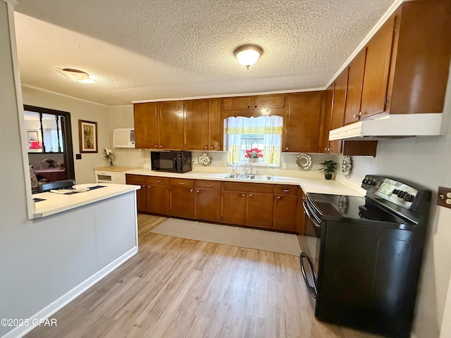 kitchen featuring a textured ceiling, crown molding, sink, black appliances, and light hardwood / wood-style flooring