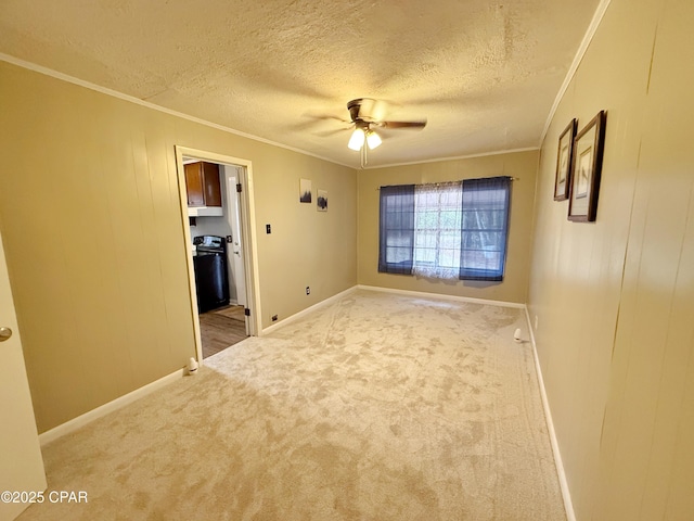 empty room with a textured ceiling, ceiling fan, ornamental molding, and carpet floors