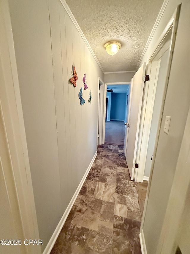 hallway featuring crown molding and a textured ceiling