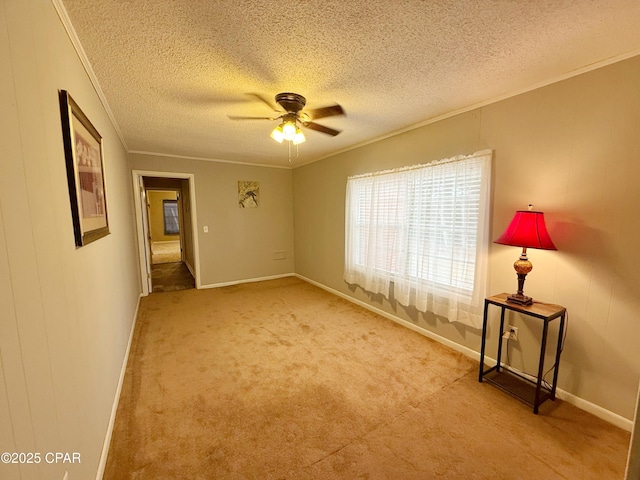 unfurnished room featuring a textured ceiling, light colored carpet, ceiling fan, and ornamental molding