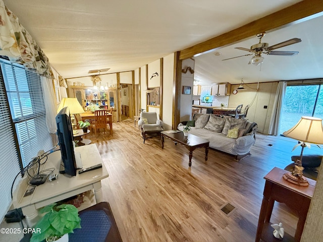 living room featuring lofted ceiling with beams, light hardwood / wood-style flooring, and ceiling fan