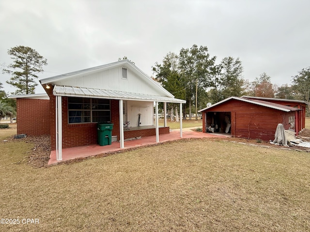 rear view of house with an outdoor structure and a yard