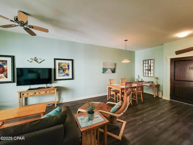 living room with ceiling fan and dark wood-type flooring