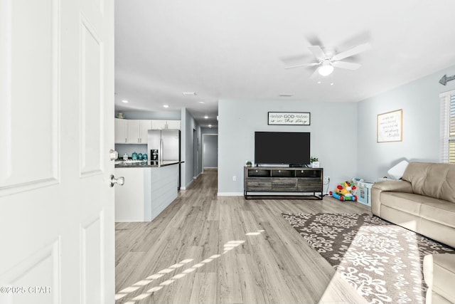 living room with light wood-type flooring and ceiling fan