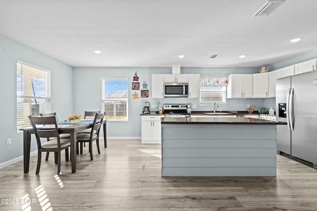 3111 E 2nd Plz, Panama City, FL 32401 - kitchen featuring appliances with stainless steel finishes, white cabinets, healthy amount of natural light, dark countertops, and recessed lighting