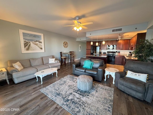 living room featuring ceiling fan and dark hardwood / wood-style floors