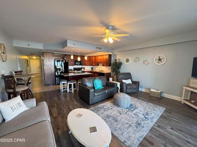 living room featuring ceiling fan, dark hardwood / wood-style flooring, and sink