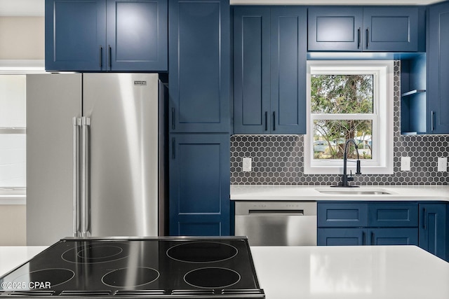 kitchen featuring decorative backsplash, sink, blue cabinets, and appliances with stainless steel finishes