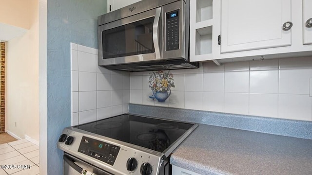 kitchen featuring tasteful backsplash, white cabinets, and appliances with stainless steel finishes