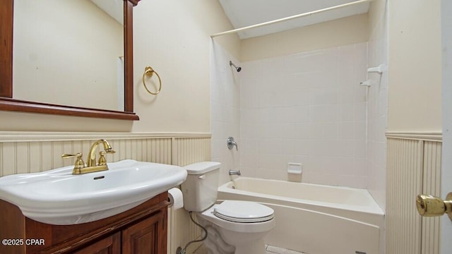 full bathroom featuring vanity, tiled shower / bath, and toilet