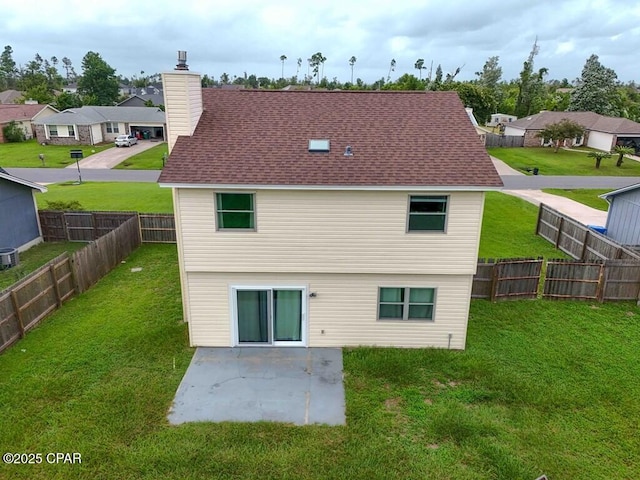 rear view of house with a yard, central AC unit, and a patio area