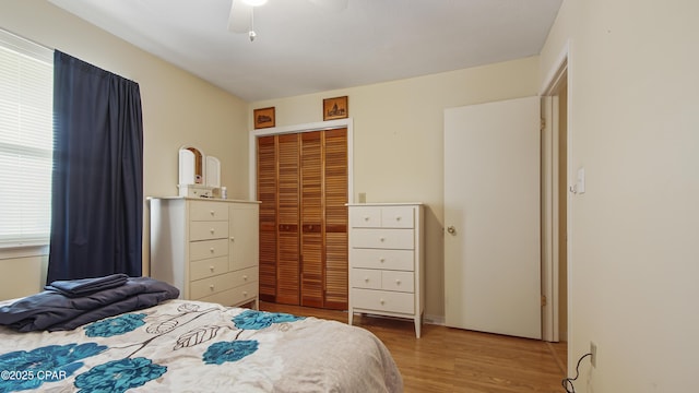 bedroom with hardwood / wood-style flooring, ceiling fan, and a closet