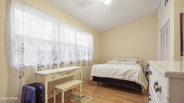 bedroom featuring ceiling fan, lofted ceiling, and light wood-type flooring