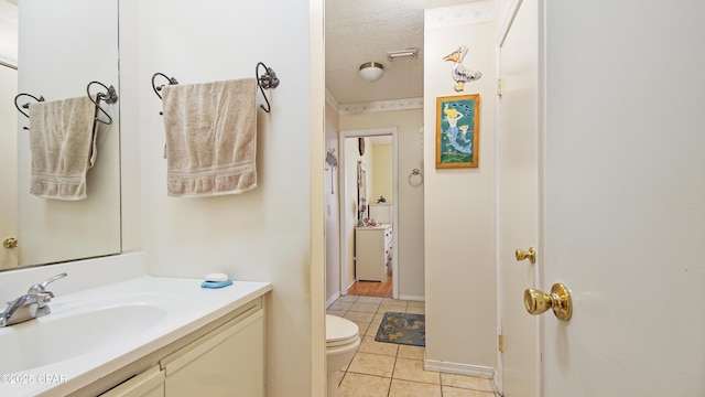 bathroom with tile patterned flooring, vanity, a textured ceiling, and toilet