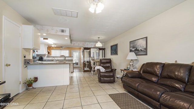 tiled living room with ceiling fan and sink