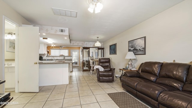 living room featuring sink, ceiling fan, and light tile patterned flooring