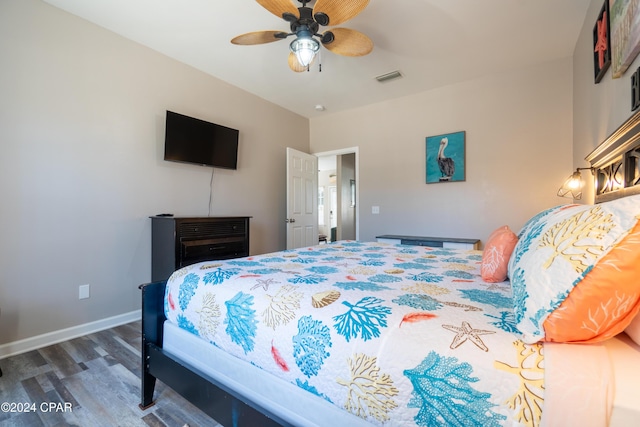 bedroom with dark hardwood / wood-style floors and ceiling fan