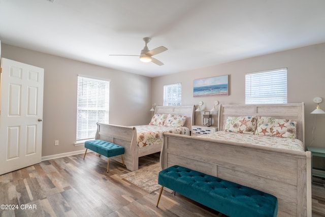 bedroom with multiple windows, hardwood / wood-style floors, and ceiling fan