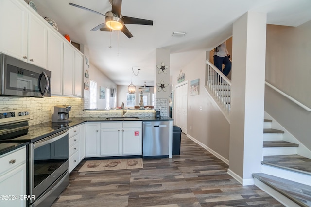 kitchen featuring appliances with stainless steel finishes, sink, white cabinets, backsplash, and kitchen peninsula