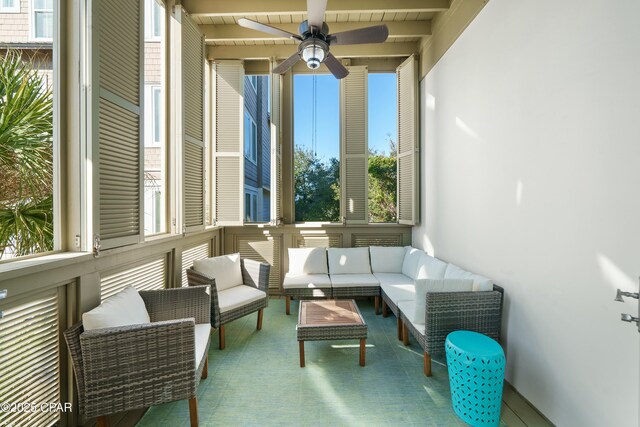 sunroom featuring beamed ceiling, ceiling fan, and wood ceiling