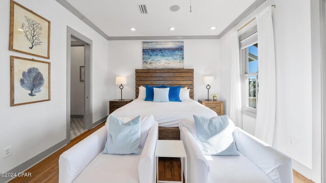 bedroom featuring light wood-type flooring and ornamental molding