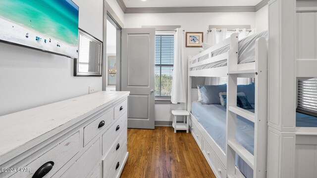 bedroom with dark hardwood / wood-style floors and crown molding