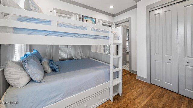 bedroom with dark hardwood / wood-style floors and a closet