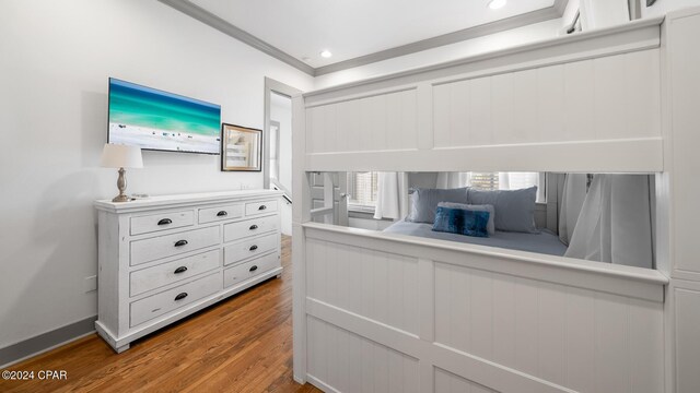 bedroom featuring wood-type flooring and ornamental molding