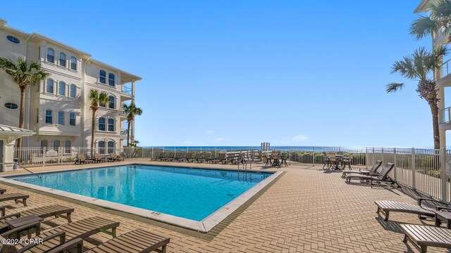 view of pool featuring a patio area and a water view