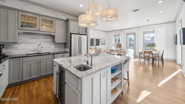 kitchen featuring pendant lighting, gray cabinets, high end fridge, and sink