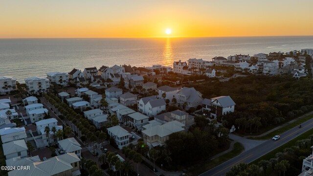 aerial view at dusk featuring a water view