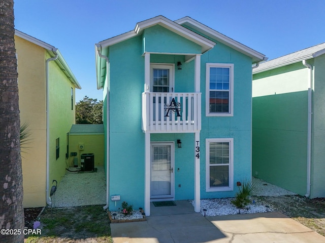 view of front of home with cooling unit and a balcony