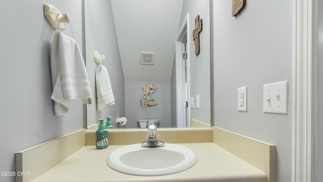 bathroom featuring vanity, toilet, and a textured ceiling