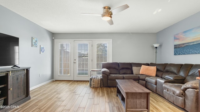 living room featuring a textured ceiling, light hardwood / wood-style floors, and ceiling fan