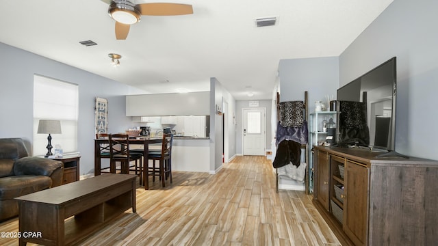 living room featuring light wood-type flooring and ceiling fan