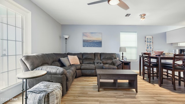 living room with ceiling fan, light hardwood / wood-style flooring, and a healthy amount of sunlight