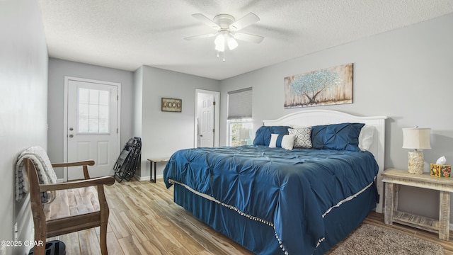 bedroom featuring ceiling fan, wood-type flooring, and a textured ceiling