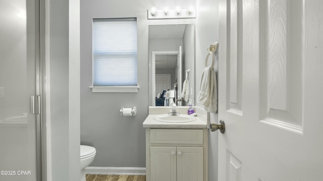 bathroom with vanity, toilet, and a shower with door