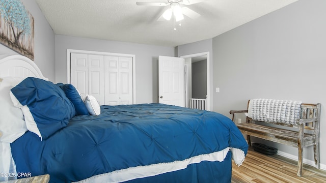 bedroom with wood-type flooring, a textured ceiling, a closet, and ceiling fan