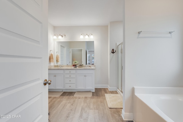 bathroom with vanity, shower with separate bathtub, and hardwood / wood-style floors