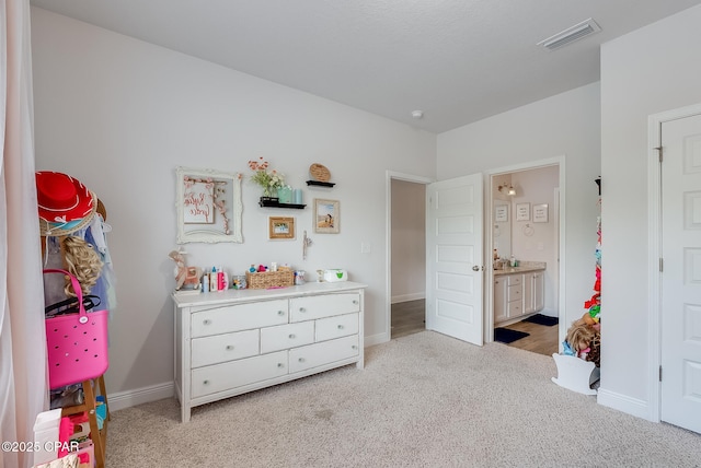 carpeted bedroom featuring ensuite bath