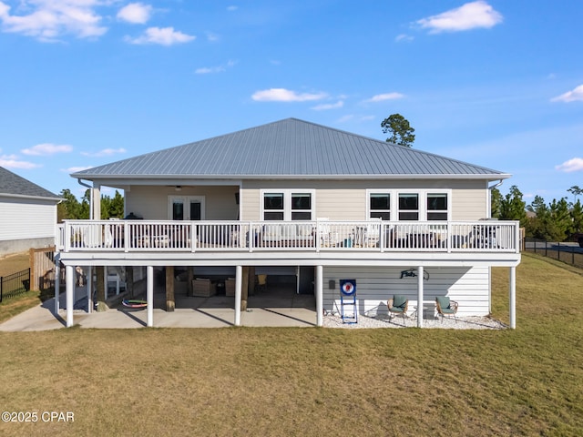 rear view of house with a wooden deck, a patio, and a lawn