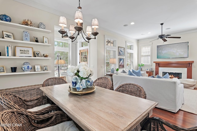 dining room featuring crown molding, dark hardwood / wood-style flooring, and ceiling fan with notable chandelier