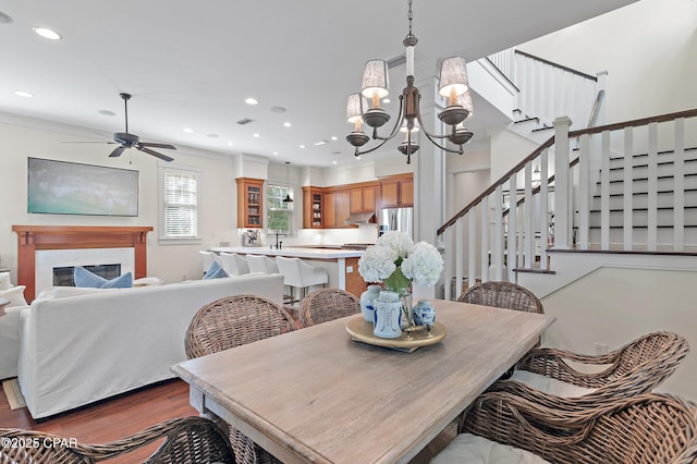 dining room featuring ceiling fan with notable chandelier and dark wood-type flooring