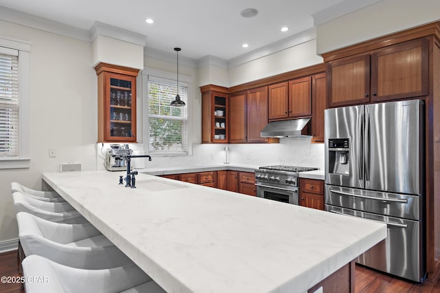 kitchen with pendant lighting, sink, a breakfast bar area, kitchen peninsula, and stainless steel appliances