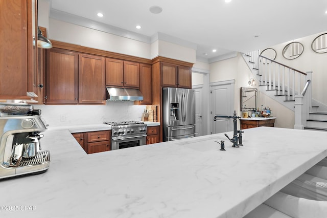 kitchen featuring kitchen peninsula, appliances with stainless steel finishes, tasteful backsplash, and sink