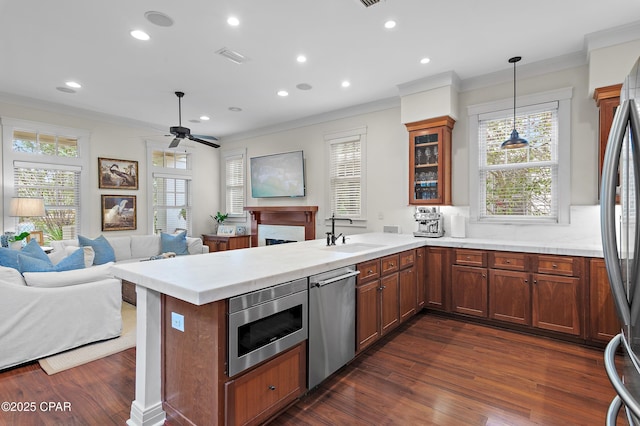 kitchen with sink, kitchen peninsula, hanging light fixtures, and appliances with stainless steel finishes